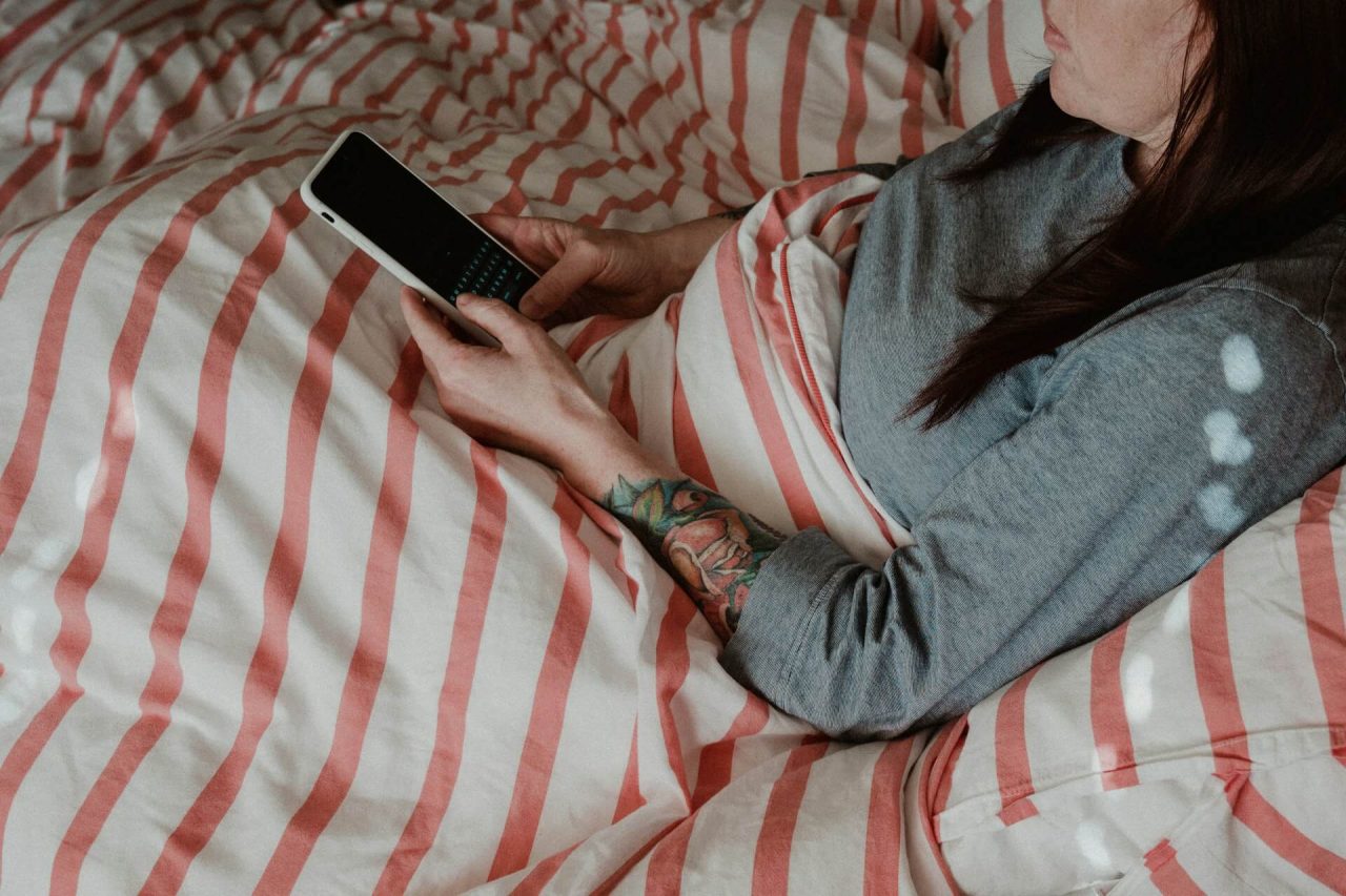 Mobilní aplikace pro sledování spánku používaná v posteli před usnutím